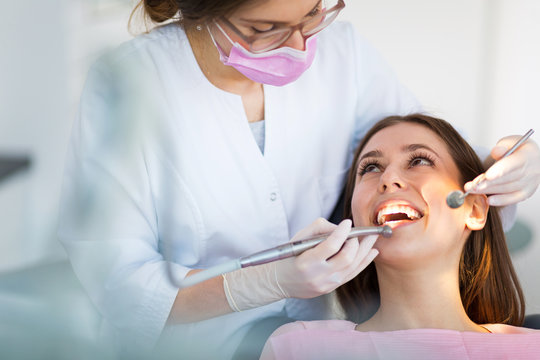 A Lady doctor treatment of a patient she wear pink mask and and white coat and glows